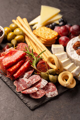 Charcuterie board with spanish jamon, pork sausage with pepper, fuet, cheese and berries