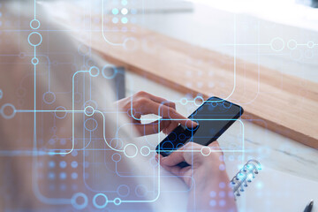 Businesswoman in formal wear holding in the hands a smart phone and testing an innovative application to provide a completely new service. Close up shot. Hologram tech graphs. Concept of Dev team.