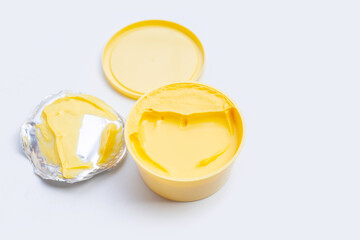 Open round container with butter or margarine on white