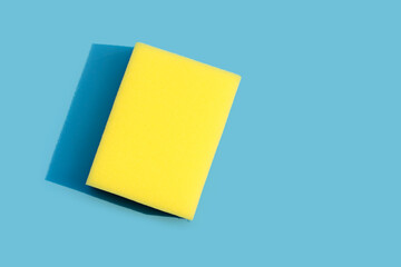 Dishwashing sponge on blue background.