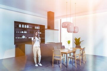 Woman near kitchen set, grey modern furniture with window, toned image