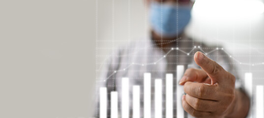 The man's finger points to the graph. Business men's hands are pointing graphs. Concept, businesses are recovering during the coronavirus (covid-19) outbreak. Selective focus. Blurred background.