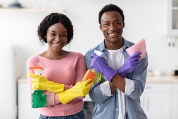 Beautiful black couple posing with cleaning tools
