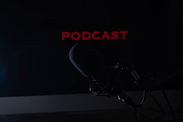 Condenser microphone on podcast background, dark setting 