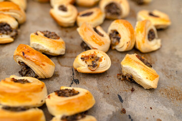 Freshly baked golden patties with mushrooms lying on baking paper.
