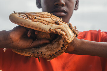 boy with brown skin and latin origin playing baseball in the park with ball, glove and bat, dark Dominican boy with baseball uniform and cap - obrazy, fototapety, plakaty