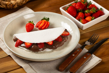 Sweet tapioca stuffed with chocolate and strawberry. Brazilian tapioca.