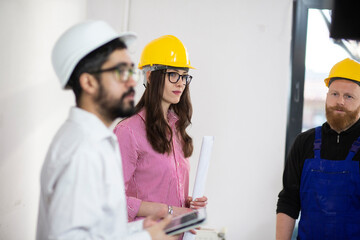 Engineers and construction worker in hardhats