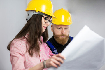 Engineer and construction worker looking at plan