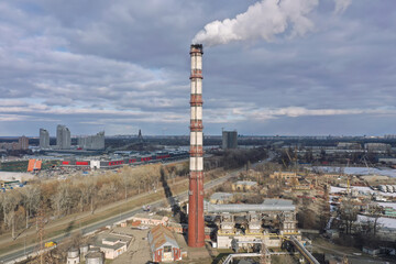 Pipes with white smoke. Pipes of a city gas boiler room with white smoke against a sky. Top view from a drone.