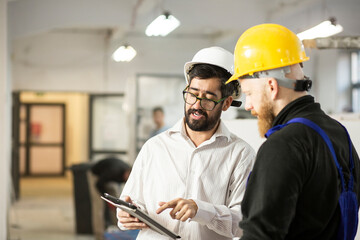 Engineer talking with construction worker