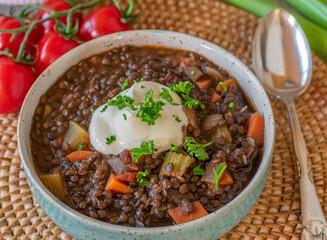 Beluga lentil stew with sour cream in a bowl