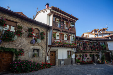 traditional Spanish houses with balcony and flowers on a sunny day