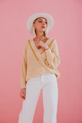 Elegant woman wearing trendy yellow v-neck sweater, white jeans, stylish silver wrist watch, white...