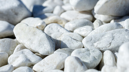 Close-up of light gray pebbles, smooth stones in a wrap-up plan as a background or wallpaper selected focus