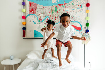 Kids jumping in the bed.