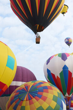 Several beautiful hot air balloons taking off at a festival