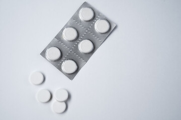 white capsule pills on a white table