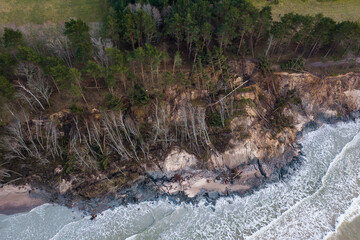 Steep shore with trees and stairs slipped under the influence of rain and wind. Dangerous place. Photographed from above. Labrags, Latvia.