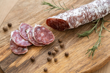 Traditional salami sliced on cutting board. Top view on dark slate table