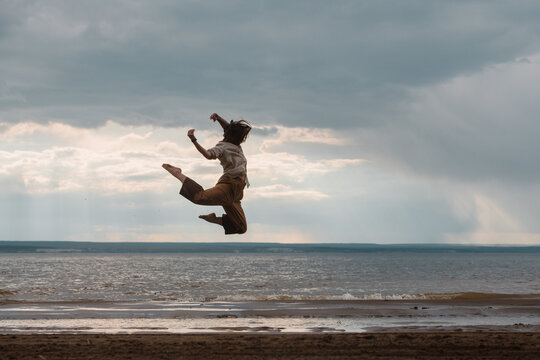 Professional dancer jumping high on the beach