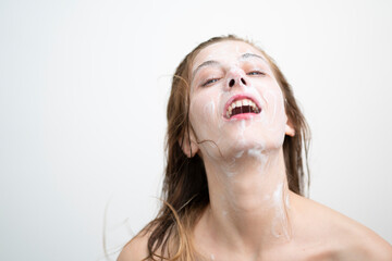 Happy Young Woman Washing her Face with Cream, Studio Shot on White Background