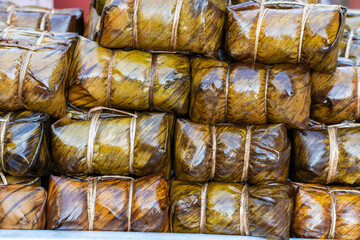 Deep fried chicken wrapped in green pandan leaves at street food market in Thailand. Thai food concept