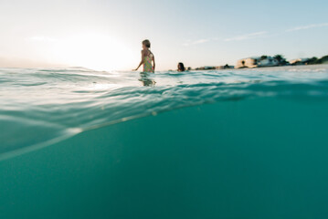 Kids playing above and below the waves