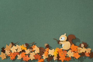 Fluffy red squirrel holds a nut in its paws, paper cut concept