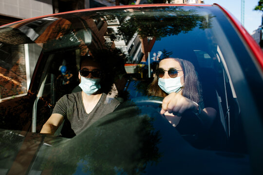 Couple with face masks in the car