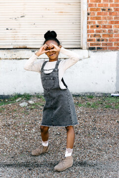 A cute little girl making a heart gesture with her hands