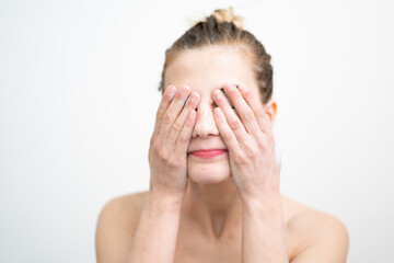 Happy Young Woman Applying Cream on Her Face, Studio Shot on White Background