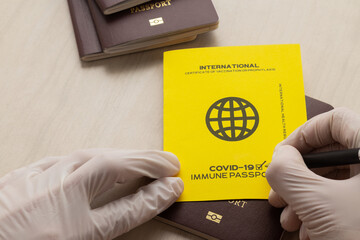 Hand signing vaccine passports as proof that the holder has been vaccinated against Covid-19, Requirement for international travel.
