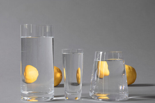 Glasses filled with water with reflections of lemons