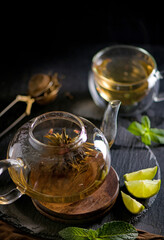 Tea concept, teapot with tea surrounded on wood background, tea ceremony, green tea in a transparent cup