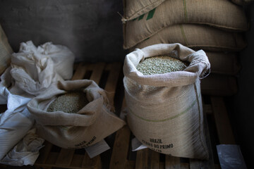 Green coffee beans in burlap sack at roaster company