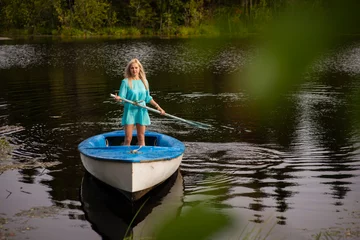 Foto op Canvas A woman riding on the back of a boat in a body of water © Ekaterina