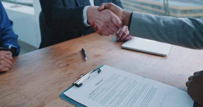 Manager and recruiter shaking hands with candidate