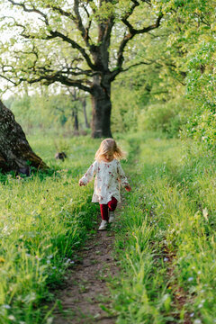 Child hopping on path in forest