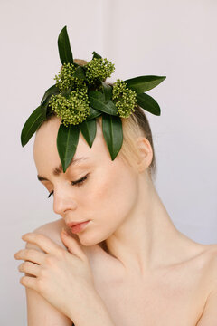 Sensual portrait of a young blond girl with a flower on her head