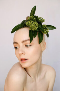 Sensual portrait of a young blond girl with a flower on her head
