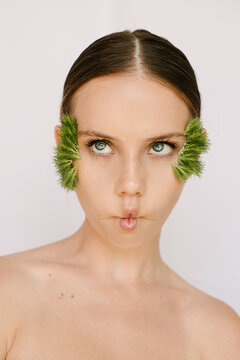 Sensual portrait of a blue eyes pretty girl with flowers on her face