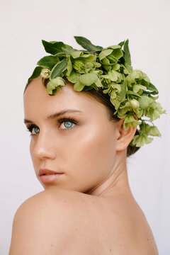 Sensual portrait of a young blue-eye's girl with flowers covering her head