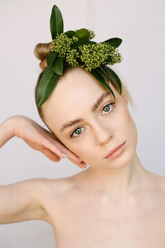 Clean portrait of a young blond girl with a flower on her head
