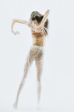 Young woman wrapped in plastic