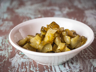 Sliced pickled cucumber in a deep plate, preparation for salad