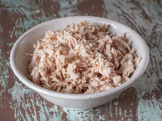 Shredded chicken in a deep plate for making salad