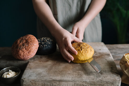 Woman's Hands Cutting Colorful Vegan Burgers