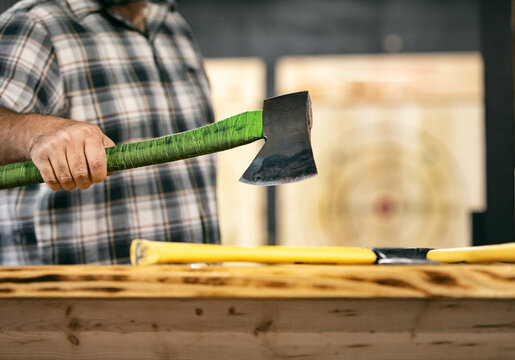 Man In Plaid Lifting Axe From Counter