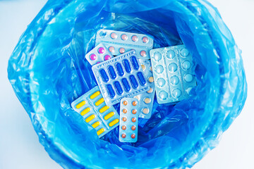 Throw away the tablets in the trash bin. Selective focus.